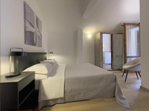 a bedroom with a large bed and a chair at Appartamenti Alighieri in Bardolino