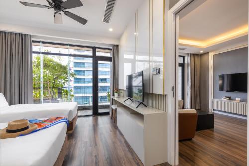 a hotel room with a bed and a flat screen tv at Chi House Danang Hotel and Apartment in Da Nang