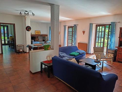 uma sala de estar com um sofá azul e uma mesa em Casa sul Lago di Lugano - Besano / Porto Ceresio em Besano