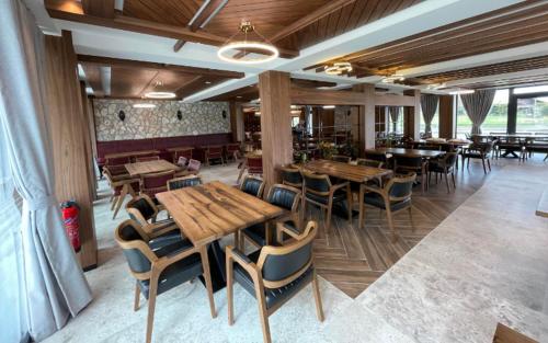 a restaurant with wooden tables and chairs in a room at Hôtel Restaurant & Spa Les Planets in Les Rasses