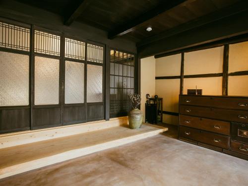Habitación con ventanas, tocador y jarrón. en 龍野城下町古民家ホテル kurasu en Tatsuno