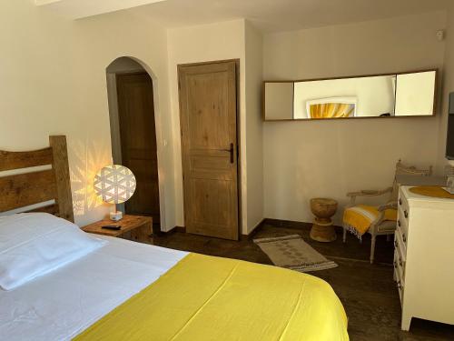 a bedroom with a yellow bed and a mirror at Le Clos des Sept Palmiers in Cavalaire-sur-Mer