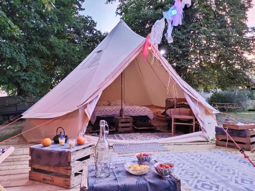 une tente dans un jardin avec une table devant dans l'établissement Le Bivouac, à Cabariot