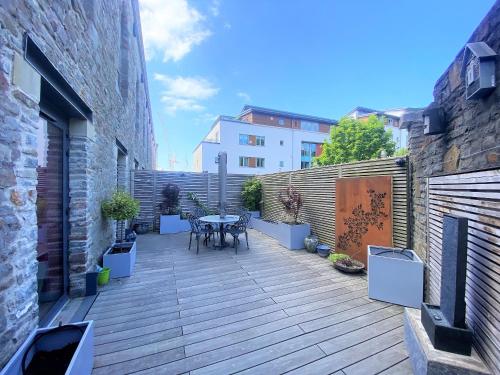 a wooden deck with a table in a building at Sublime waterfront retreat with private terrace in Bristol