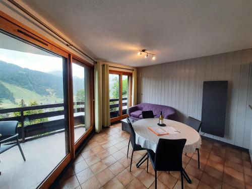 Cette chambre dispose d'une table, de chaises et d'un balcon. dans l'établissement Les Balcons de Morzine, à Morzine