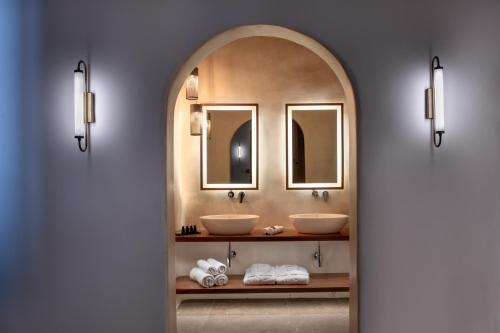 a bathroom with two sinks and two mirrors at Victoria Caves in Vóthon