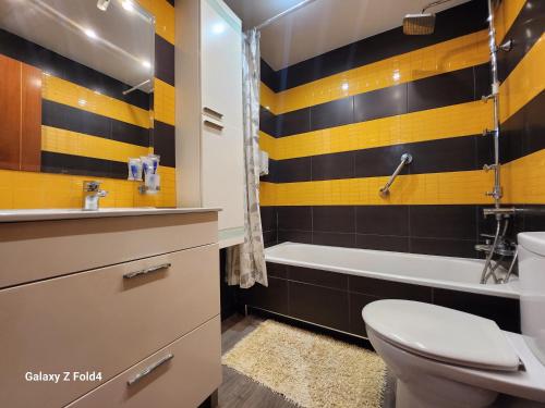 a bathroom with a toilet and a sink and a tub at VILLA ARTEP Lujoso apartamento con piscina comunitaria in Cartagena