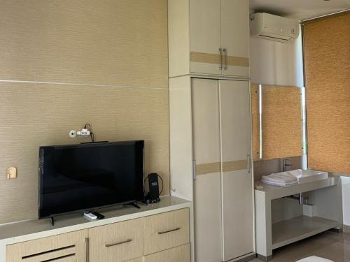 a living room with a television on a cabinet at Sawah Joglo Boutique Villa Mitra RedDoorz in Ngaglik