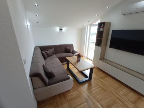 a living room with a couch and a flat screen tv at Apartmani Vasković in Trebinje