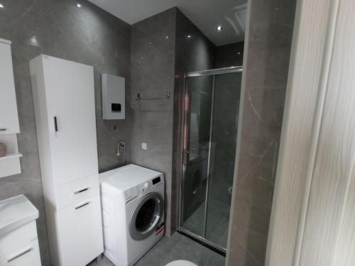 a bathroom with a washing machine and a washer at Apartmani Vasković in Trebinje