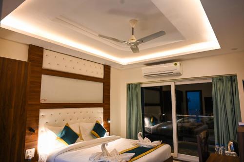 a bedroom with a bed with a ceiling fan at Hotel 7 Heaven in Dehradun