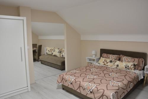 - une chambre avec un lit et un canapé dans l'établissement Garden apartmani, à Jagodina