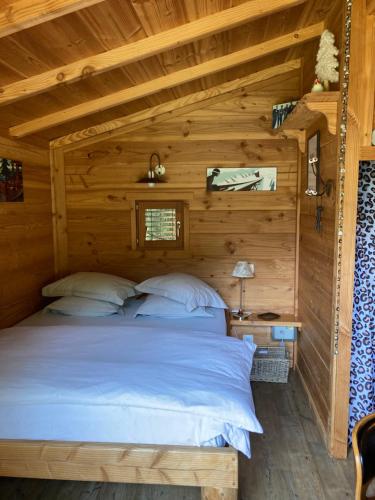 una camera da letto in una baita di tronchi con letto di la Cabane dans les Arbres a Saint-Jean-d'Aulps