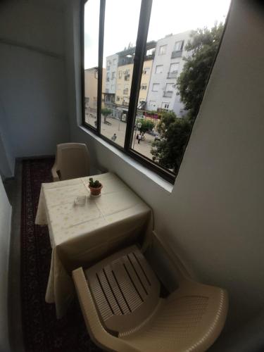 a small table and chair in a room with a window at Centar Apartment in Gevgelija