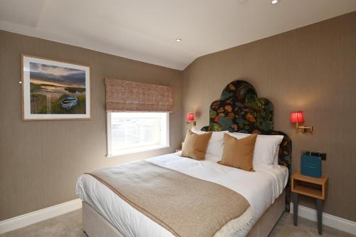 a bedroom with a large bed and a window at The Bell Hotel, Saxmundham in Saxmundham
