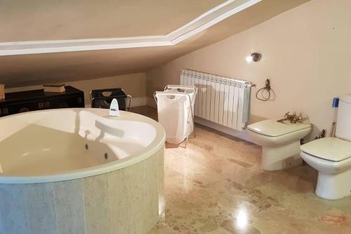 a bathroom with a bath tub and a toilet at Casa de lujo con piscina privada, cerca de Madrid in Villalbilla