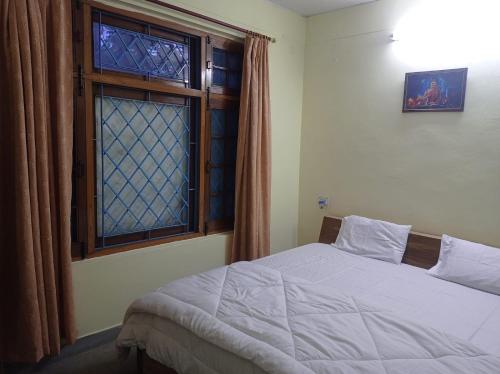 a bedroom with a bed and a window at The Pine View Home Stay in Almora