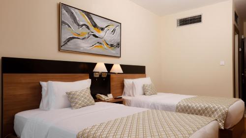 a hotel room with two beds and a phone at La Vida Suite in Beirut