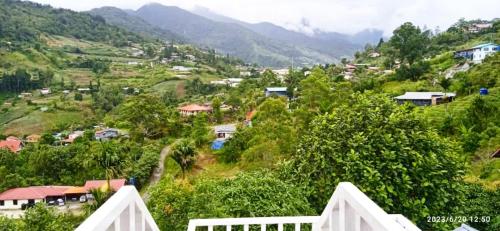 a small village on a hill with houses and trees at Dongorit Cabin Deluxe Room in Kundasang