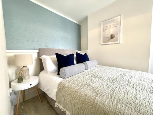 a bedroom with a large bed and a night stand with a lamp at New Seaside Apartment 2 Porthcawl in Porthcawl