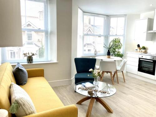 een woonkamer met een bank en een tafel bij New Seaside Apartment 2 Porthcawl in Porthcawl