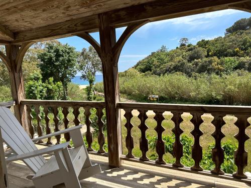 a porch with a chair and a view of the countryside at Le Clos des Sept Palmiers in Cavalaire-sur-Mer