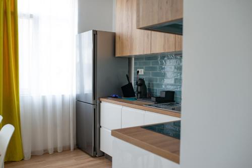 a kitchen with white cabinets and a black refrigerator at Apartment next to Mall Plovdiv in Plovdiv