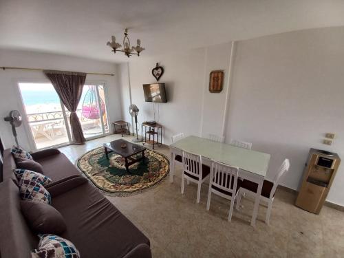 a living room with a couch and a table and chairs at شالية علي البحر بالعين السخنة بقرية امباير ريزورت in Ain Sokhna