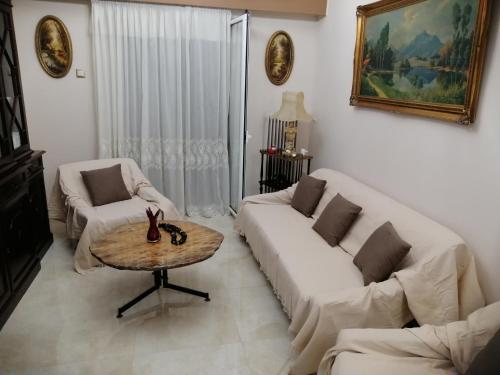 ein Wohnzimmer mit Sofa und Tisch in der Unterkunft Comfy Apartment For 4 Ppl In Koukaki in Athen