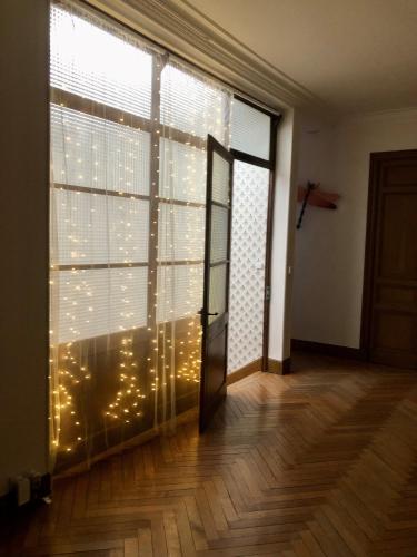a room with a large window with christmas lights at La Grande Maison Mazamet in Mazamet