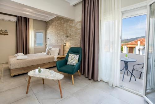 a hotel room with a bed and a table and a chair at Le Vieux Quartier in Limenaria