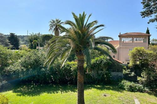 a palm tree in front of a house at Lovely 4-person apartment 200 m from beaches Cap d'Antibes in Juan-les-Pins