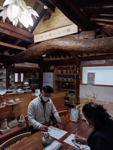 a man and a woman sitting at a wooden table at Yasun Gallery in Gyeongju
