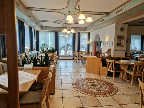 a restaurant with tables and chairs and windows at LandGASTHOF Rose in Dammbach