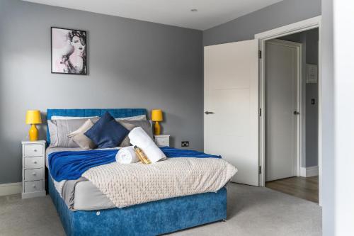 um quarto com uma cama azul e uma cabeceira azul em Livestay-One Bed Apt in Slough with FREE Parking em Slough