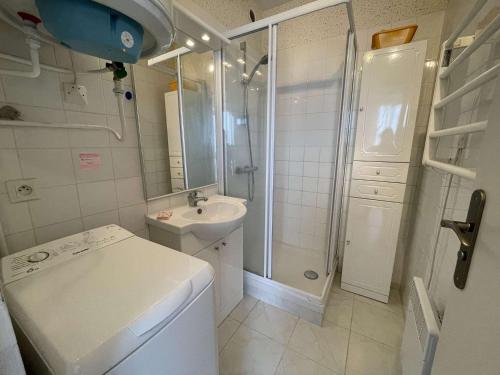 La salle de bains blanche est pourvue d'une douche et d'un lavabo. dans l'établissement Appartement Saint-Hilaire-de-Riez, 2 pièces, 5 personnes - FR-1-224C-685, à Saint-Hilaire-de-Riez