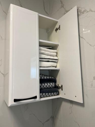 a white cabinet with towels and towels in a bathroom at Krasta Home apartament Parking & With CITY & RIVER VIEW in Riga