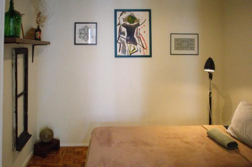 - une chambre avec un lit et trois photos sur le mur dans l'établissement Boho Chic Apt, à Vila Franca de Xira