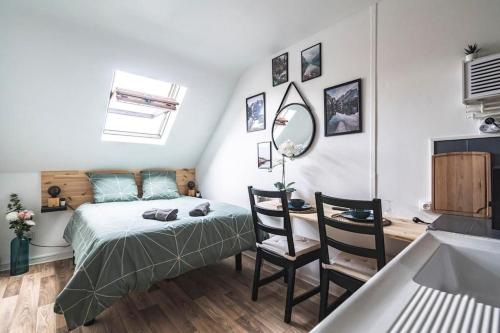 - une chambre avec un lit et un bureau avec un miroir dans l'établissement L'escale studio proche de la gare, à Reims