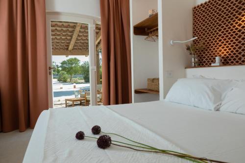 Un dormitorio con una cama blanca con flores. en Pozzo Traverso Casale, en Leporano Marina