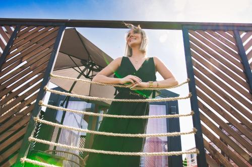 Una mujer con un vestido verde parada en un columpio en Holiday Park Zator Resort & Spa, en Zator