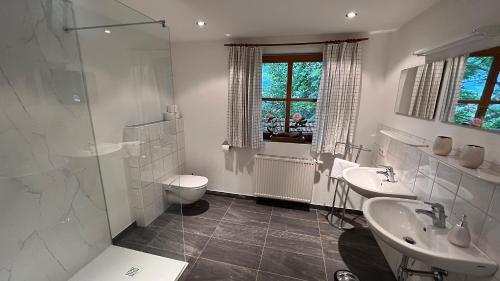 a bathroom with two sinks and a shower and a toilet at Appartement am Mühlrain in Saalfelden am Steinernen Meer