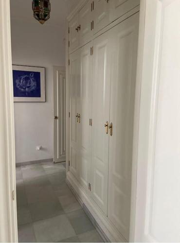 a white room with white cabinets and a hallway at Apartamento encantador en Sevilla in Seville