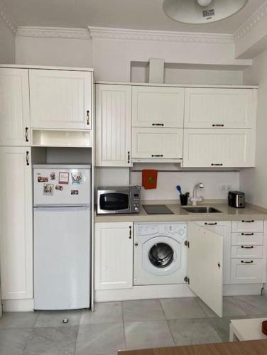 uma cozinha com armários brancos e uma máquina de lavar e secar roupa em Apartamento encantador en Sevilla em Sevilha