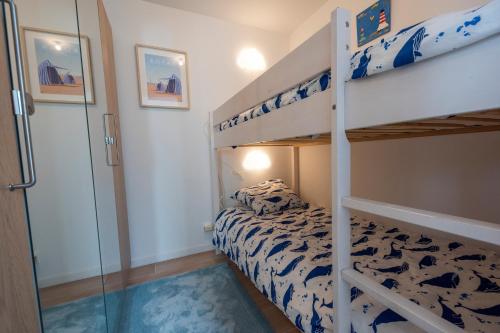 - une chambre avec 2 lits superposés et une porte en verre dans l'établissement LES SEMIS - Superbe appartement VUE MER avec jardin, à Royan