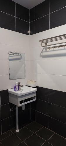a bathroom with a sink and black and white tiles at Sunsky Condominium Homestay 2 in Miri