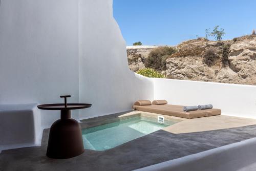 a swimming pool in a white room with a table at Victoria Caves in Vóthon