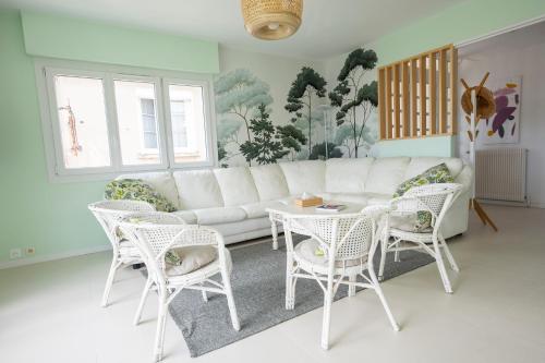 un salon avec un canapé blanc et des chaises dans l'établissement LES SEMIS - Superbe appartement VUE MER avec jardin, à Royan