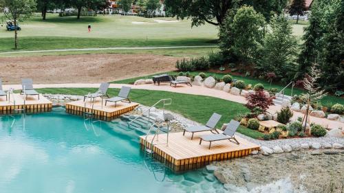 una vista aérea de una piscina con sillas en un patio en NOVA Moments Boutique Hotel, en Pertisau