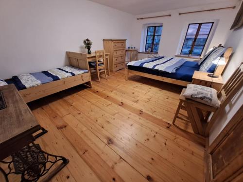 a large room with two beds and a wooden floor at Chalupa Zátyní - celý objekt in Dubá